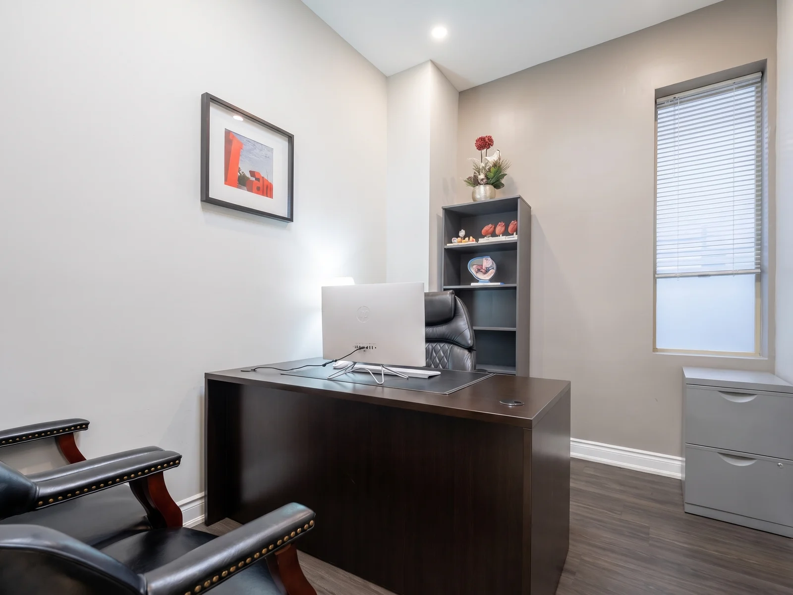 A consultation office with a desk and seating for patients