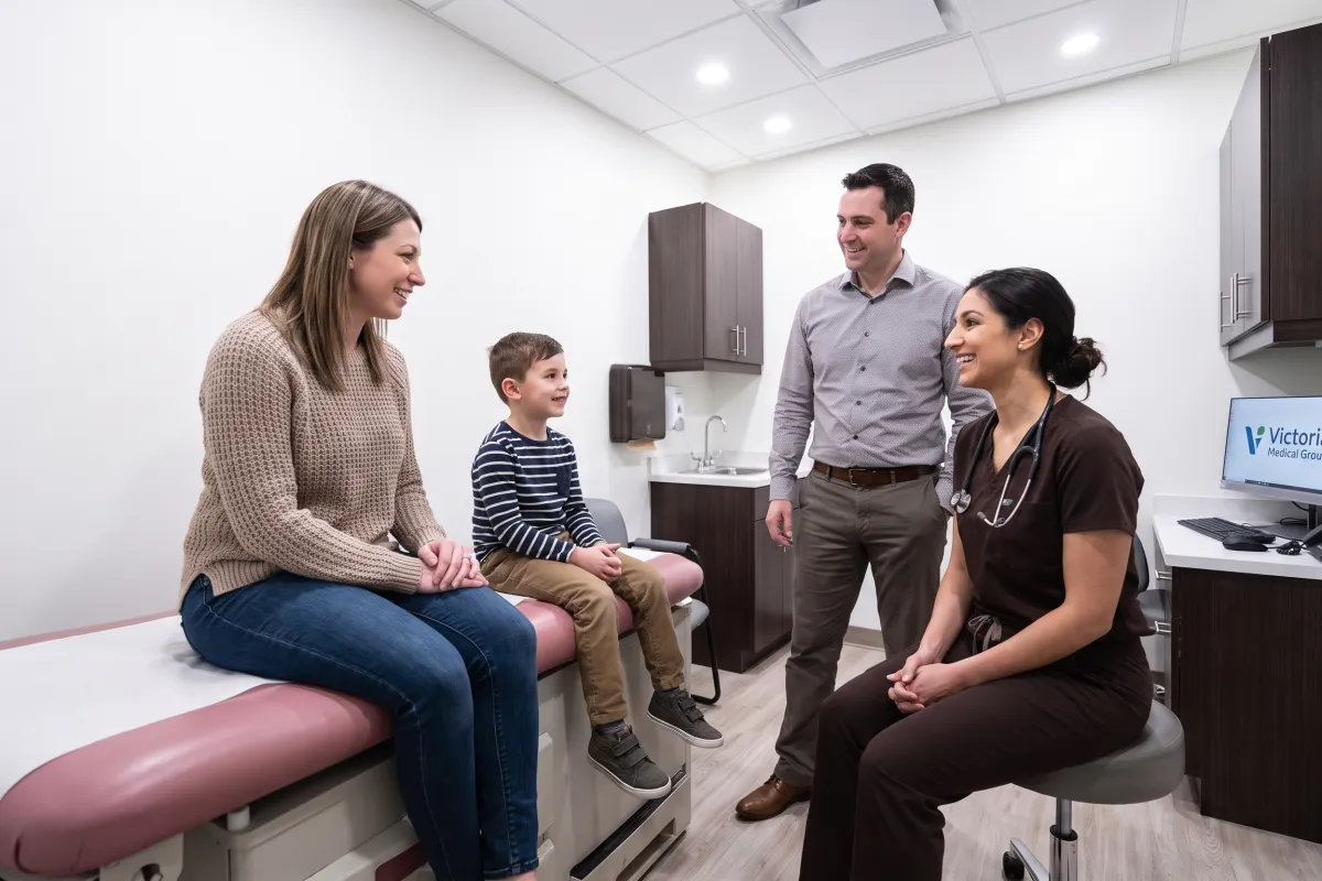 A family physician talking with a family in an exam room at Victoria Medical Group